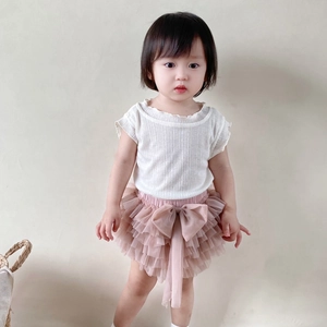 Detail of pink tiered tulle tutu skirt with big bow and white knit short sleeve top