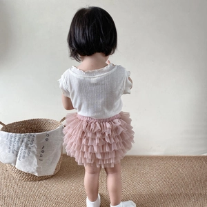 Detail of pink multi-layer mesh tutu skirt and white waffle texture top on toddler
