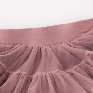 Gros plan sur la taille élastique et le tulle rose multicouche d'un jupon de fille