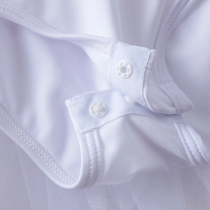Détail de la robe de ballet blanche montrant les boutons pression et les couches de tulle