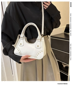 Elegante borsa bianca con borchie dorate e chiusura a girello indossata da modella