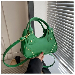 Dettaglio borsa verde brillante con borchie dorate e tracolla regolabile