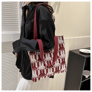 Burgundy checkered canvas tote bag with rabbit print shown on model's shoulder