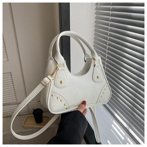 Vista dettagliata della borsa fashion bianca con borchie dorate e trama in pelle su modella