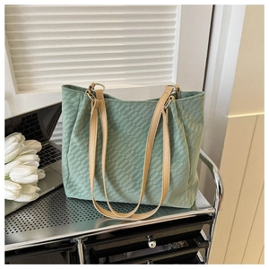 Vue détaillée du sac cabas vert clair avec texture matelassée et fines lanières