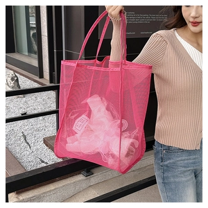 Detalle del bolso tote de malla rosa que muestra gran capacidad y textura calada