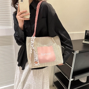 Summer woven straw tote bag with pink leather patch and silk scarf on modern model