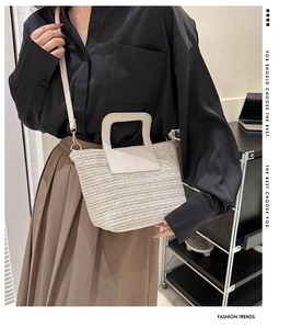Détail du sac seau tissé beige avec texture ondulée et bandoulière réglable