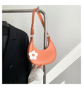 Vue détaillée d'un sac hobo pêche avec charm fleur et logo blanc imprimé
