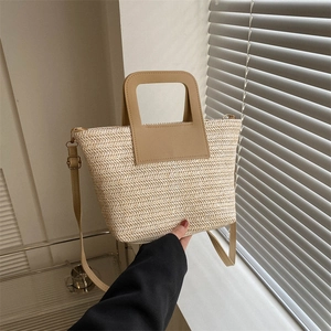 Sac seau en paille beige tendance avec bandoulière en similicuir dans un décor moderne
