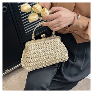 Detailansicht der gewebten beigen Handtasche mit goldenem Ringgriff und Metallverschluss