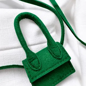 Close-up of vibrant green felt mini bag with signature curved handle and fine stitching