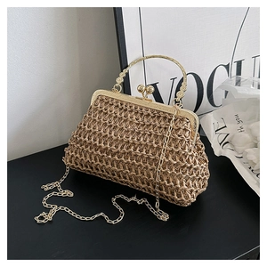 Dettaglio borsa intrecciata con chiusura a sfera dorata e manico metallico ornamentale