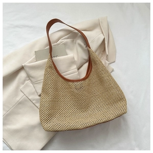 Detail of hand-woven hobo shoulder bag featuring intricate hollow patterns and leather handle