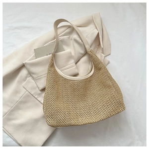Close-up of beige woven tote bag showing premium craftsmanship and leather handle