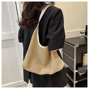 Close-up of a hand-woven brown tote bag with hollow mesh texture and beige leather edges
