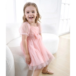 Detail of girls' pink tulle dress with white polka dots and puff sleeves for summer 2025