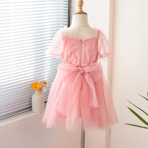Detail of pink polka dot tulle girl's dress featuring a large decorative back mesh bow