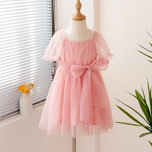 Detail of pink polka dot tulle dress for girls featuring a large mesh bow and puffy sleeves
