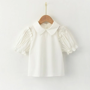 Detail of white puff sleeve shirt for girls featuring a Peter Pan collar and ruffles