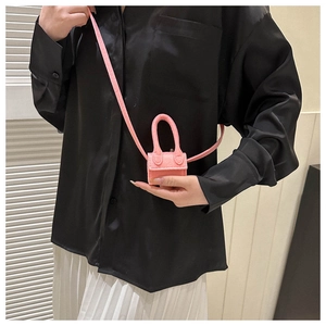 Detail view of mini pink felt crossbody bag shown on model to highlight micro size