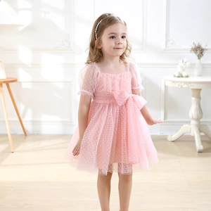 Close-up of pink polka dot tulle dress for girls featuring puff sleeves and a large waist bow