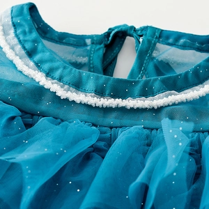 Detailed view of peacock blue mesh neckline with white beads and silver glitter