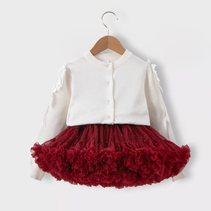 Detail der weißen Strickjacke mit Federakzenten und burgunderfarbenem Tutu für Mädchen