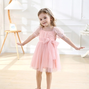 Detail of a pink tulle dress for girls featuring puff sleeves and a large waist bow