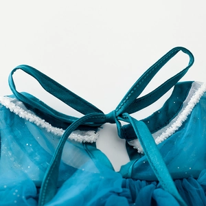 Detailed view of teal girl's dress neckline with bow closure and white beaded trim