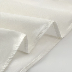 Detail shot of white puff sleeve shirt showing high-quality stitching and woven cotton texture