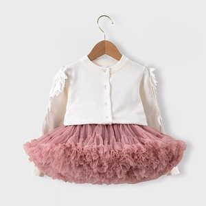 Detail der Strickjacke mit Spitzenflügel-Applikationen und rosa Tüllrock aus Tüll