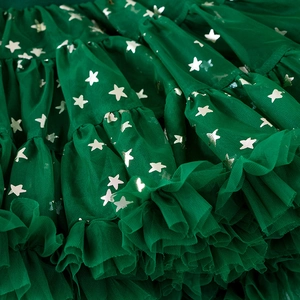 Detail of dark green tutu skirt featuring multi-layered mesh with silver star patterns
