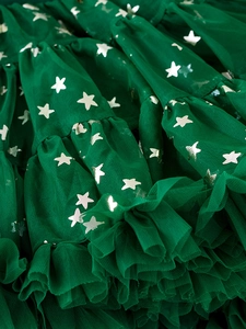 Close-up of green tulle tutu skirt with silver metallic star print and layered mesh details