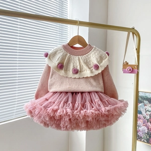 Detail of baby girl pink polka dot knit sweater with ruffle collar and fluffy tutu skirt