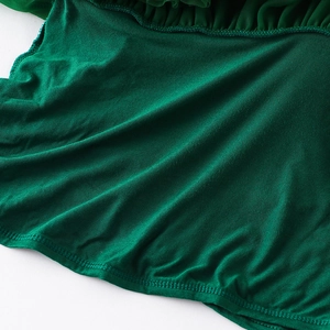 Detailed view of dark green tutu skirt stitching and pleated tulle fabric texture