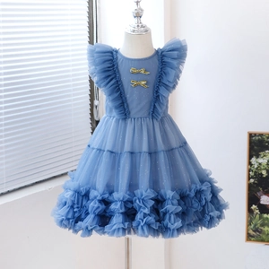 Close-up of blue girl princess dress with gold bows and tiered tulle sparkling details