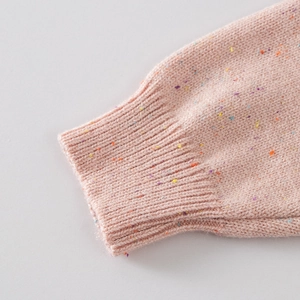 Macro detail of pink confetti knit sleeve with ribbed cuffs on girls' sweater