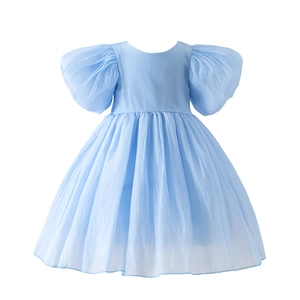 Détail d'une robe bleu clair à manches bouffantes montrant le tissu plissé et le col rond