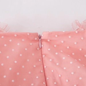 Close-up of pink tulle dress featuring white polka dots and a concealed back zipper closure