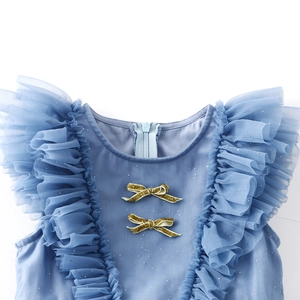 Detailed view of light blue girls' dress with mesh ruffles and golden glitter bows