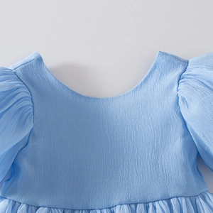 Détail de robe bleue claire pour fille avec manches bouffantes et mousseline texturée