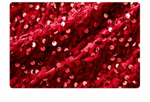 Macro shot of red sequins stitched onto premium velvet fabric for girl's dress
