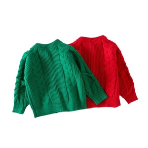Detail of red and green cable knit sweaters with ribbed cuffs and round necklines