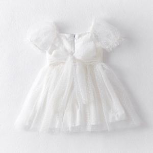 Detail of white tulle princess dress featuring puff sleeves and large bow decoration