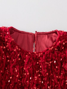 Detail of red sequined girl's dress neckline with single button closure and plush lining