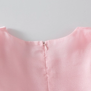 Detailed close-up of invisible back zipper on pink satin girls' princess dress