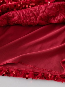 Detailed macro view of girls' crimson sequin dress with velvet fabric and hem stitching