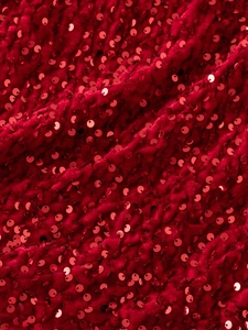 Close-up of red sequin fabric on girl's princess dress with velvet texture and sparkle