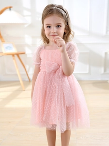 Pink tulle girls' dress with white polka dots, puff sleeves and a large bow for parties